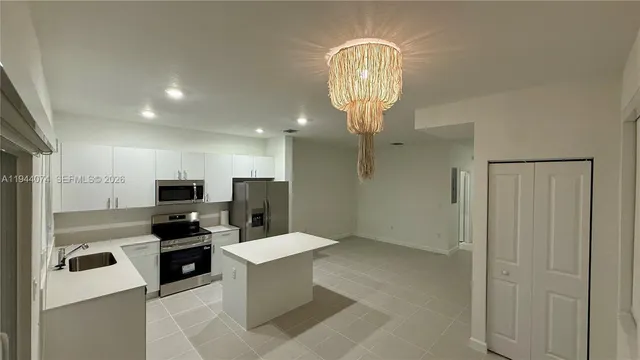 a kitchen with stainless steel appliances a refrigerator and a stove top oven