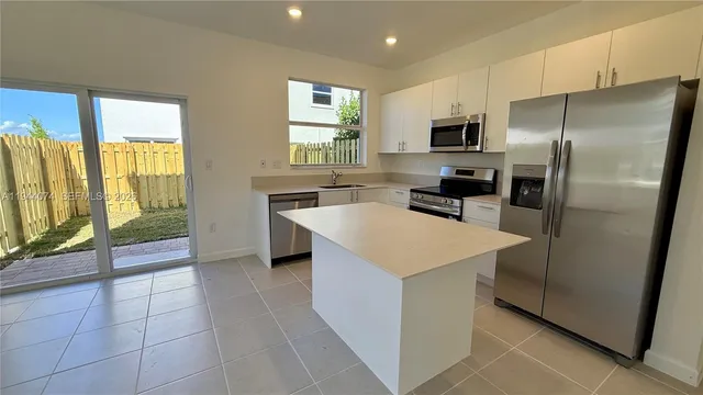 a kitchen with a refrigerator a sink and a stove top oven