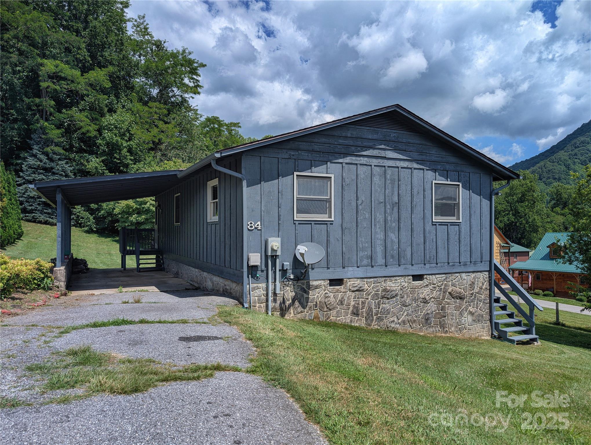 84 Stoney Ridge Loop Maggie Valley, NC 28751 - Photo 2 of 27 a backyard of a house with table and chairs