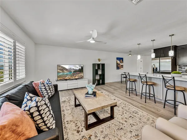 a kitchen with stainless steel appliances kitchen island granite countertop a stove a sink dishwasher a refrigerator with a dining table and chairs