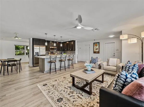 a kitchen with stainless steel appliances kitchen island granite countertop a table chairs microwave and sink