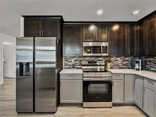 a kitchen with stainless steel appliances granite countertop a sink and wooden floors