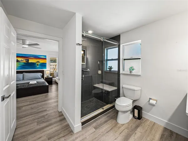 a bedroom with a bed and painting on the wall