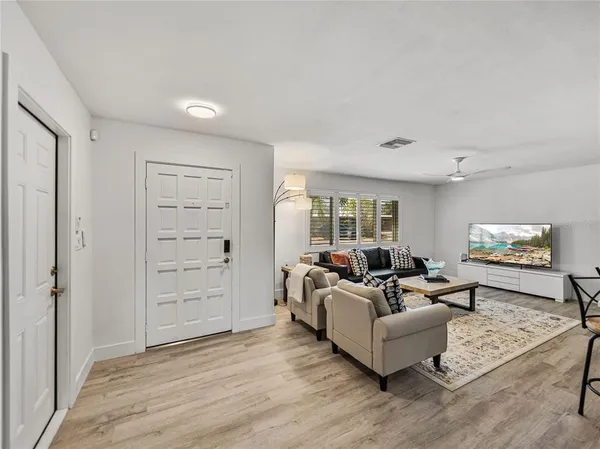 a living room with furniture wooden floor and a kitchen view