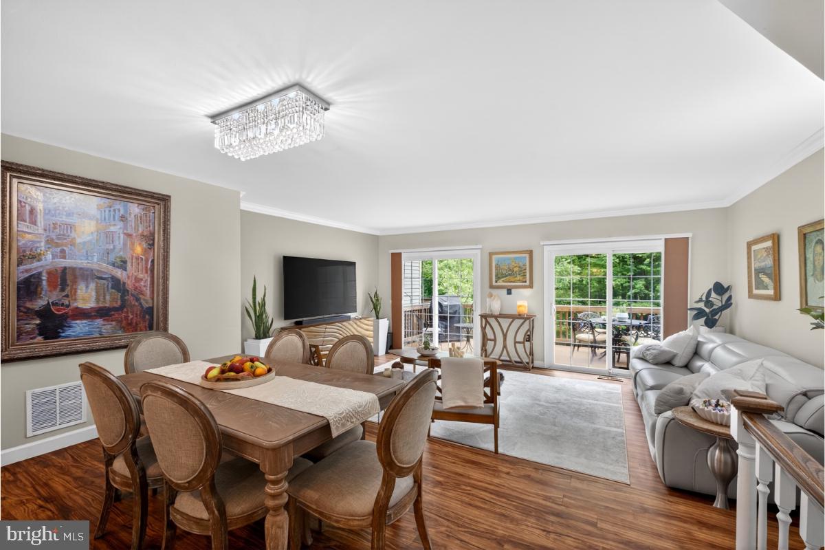 7347 Swan Point Way, Unit 122 Columbia, MD 21045 - Photo 11 of 54 a view of a dining room with furniture large windows and wooden floor