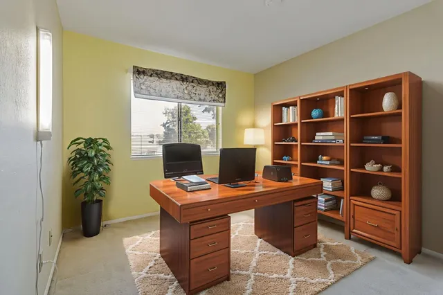 a view of a workspace with furniture and a bookshelf