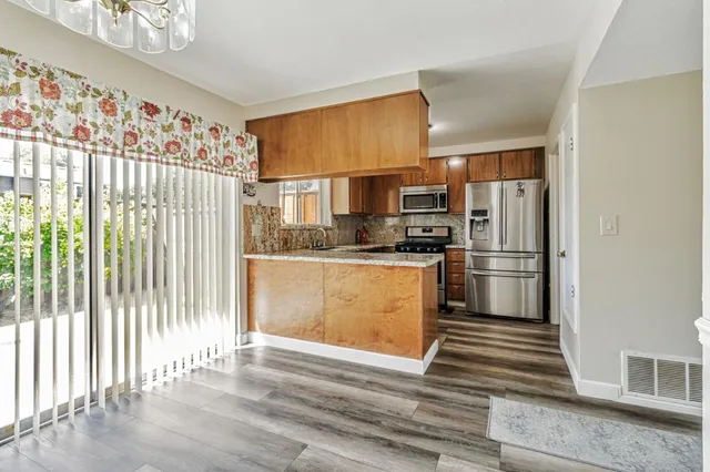 a kitchen with granite countertop a refrigerator and cabinets