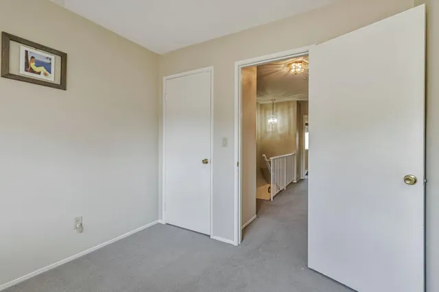 a view of an empty room with closet and mirror