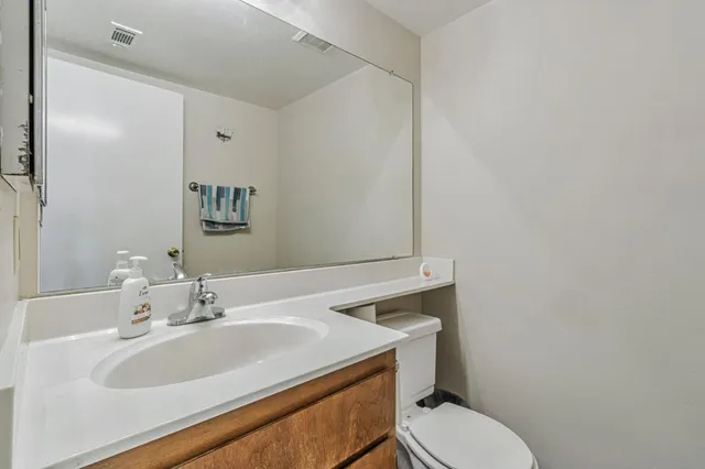 a bathroom with a sink toilet and mirror