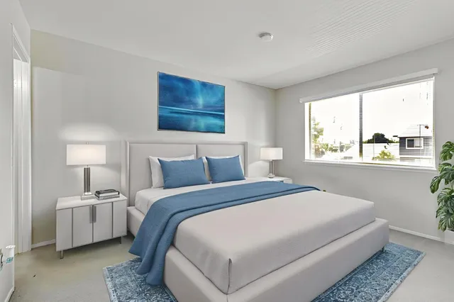 a bedroom with bed and a large window