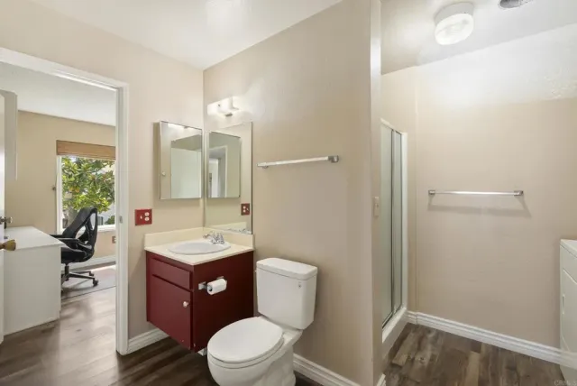 a bathroom with a toilet a sink a mirror and a shower