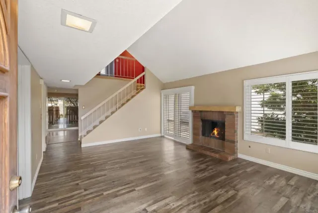 a view of empty room with wooden floor and fireplace