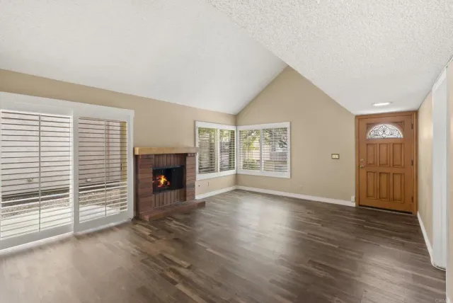 an empty room with windows and a fireplace