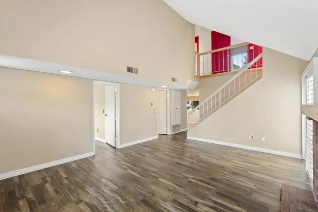 a view of hallway with stairs and wooden floor