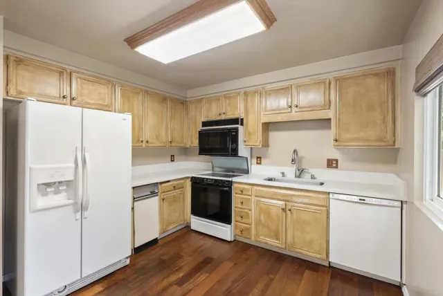a kitchen with cabinets stainless steel appliances a sink and a window