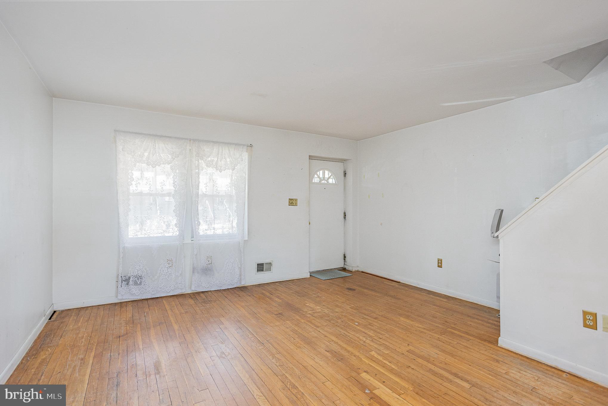 1408 Locust Street Curtis Bay, MD 21226 - Photo 5 of 25 an empty room with wooden floor and windows