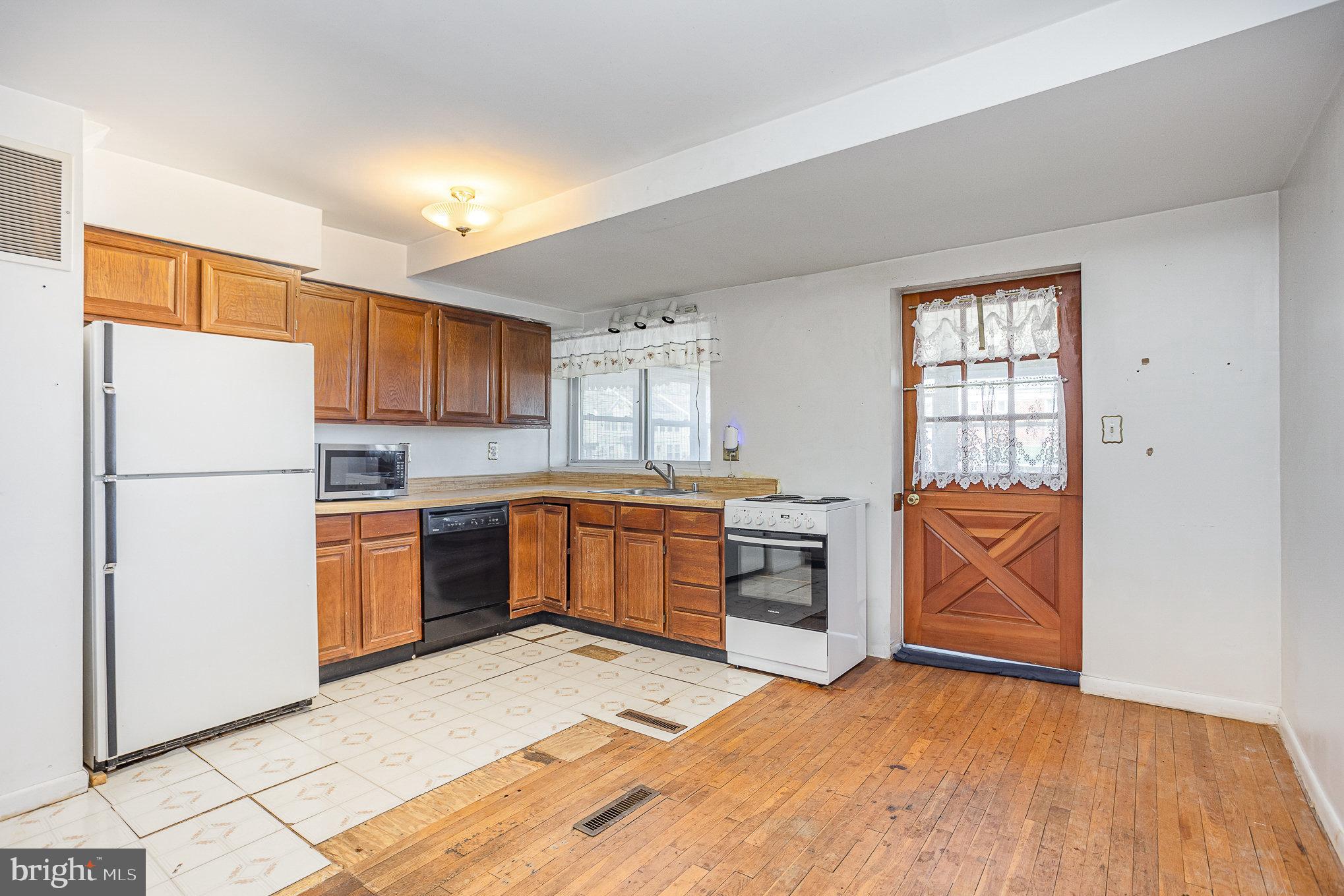 1408 Locust Street Curtis Bay, MD 21226 - Photo 6 of 25 a kitchen with stainless steel appliances granite countertop a refrigerator sink and stove