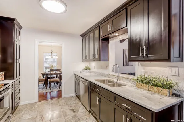 a kitchen with a sink counter top space and stainless steel appliances