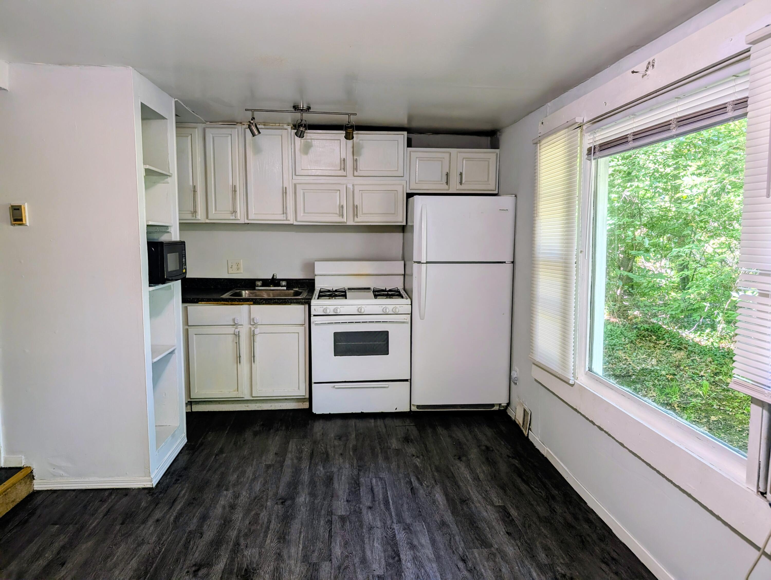 1910 South Calhoun Street Griffith, IN 46319 - Photo 3 of 19 a kitchen with a hard wood floor white cabinets and white appliances