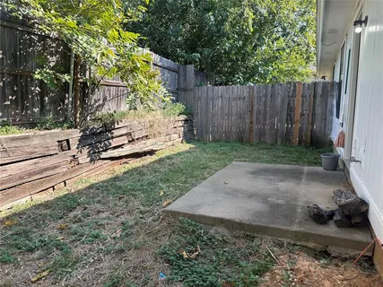 a view of a backyard with wooden fence