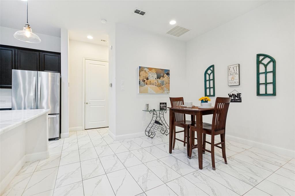 605 Ansley Way Allen, TX 75013 - Photo 10 of 28 White marble-look tile flooring throughout, complemented by a prominent stainless steel refrigerator and black cabinetry
