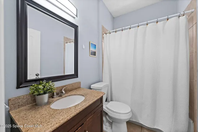 a view of a house with brick walls and a yard with plants