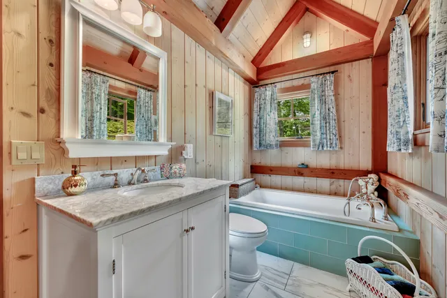 a bathroom with a granite countertop sink and a bathtub