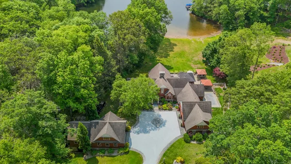 an aerial view of a house with a yard and lake view