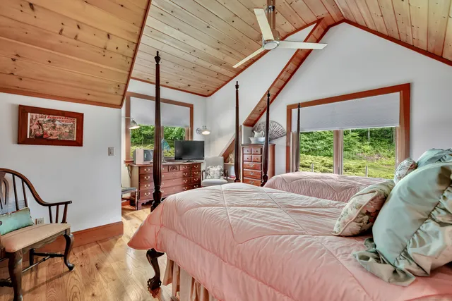 a bed sitting in a bedroom next to a window