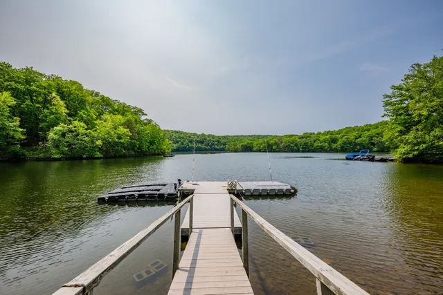 an aerial view of a house with a yard and lake view