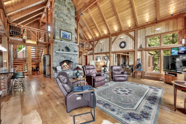 a living room with fireplace furniture and a large window