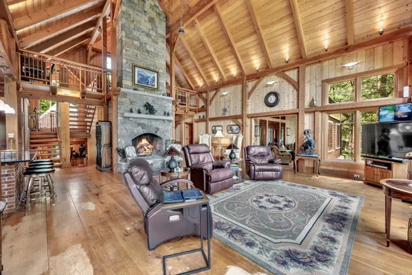 a kitchen with stainless steel appliances kitchen island granite countertop a table chairs in it and wooden floors