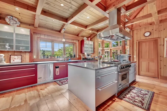 a kitchen with stainless steel appliances granite countertop a stove and large window