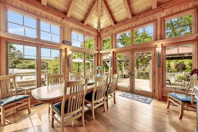 a view of a dining room with furniture large windows and wooden floor