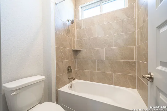 a white bath tub sitting next to a white toilet and sink