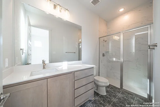 a bathroom with a sink a toilet and shower