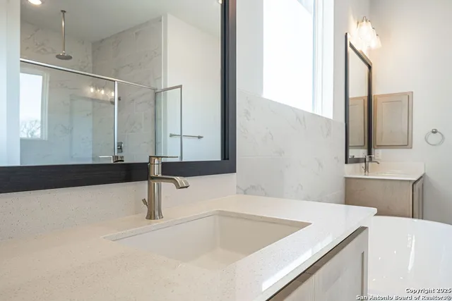 a bathroom with a tub sink and mirror