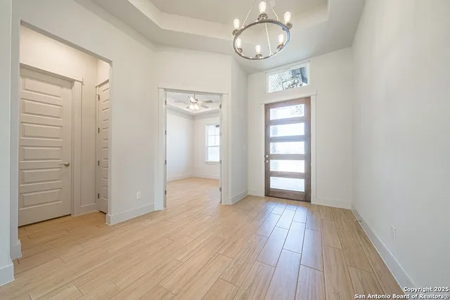 an empty room with wooden floor cabinet and windows