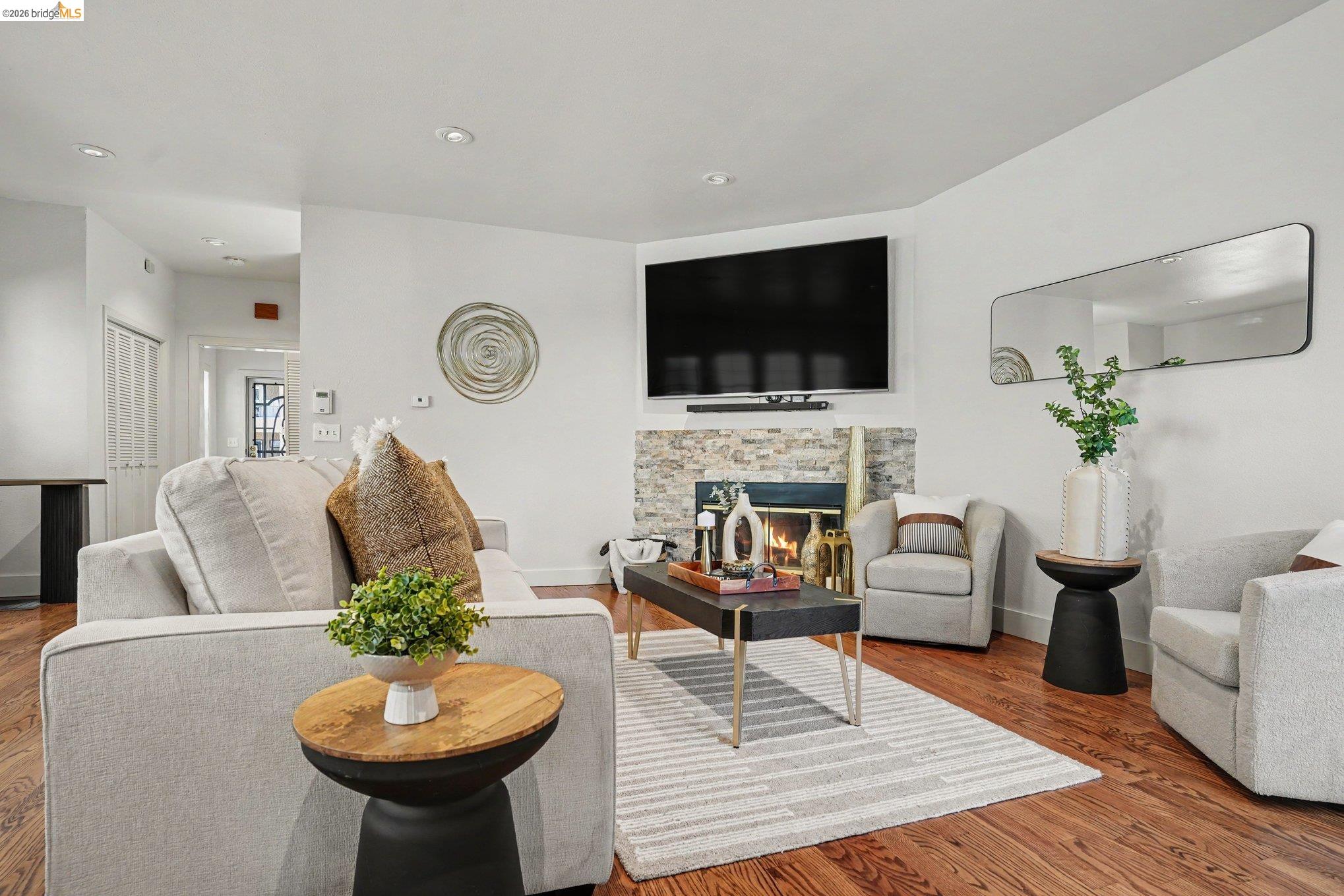 1433 Myrtle Street Oakland, CA 94607 - Photo 3 of 25 Living area featuring hardwood flooring, a stone-clad fireplace, recessed lighting, and white walls