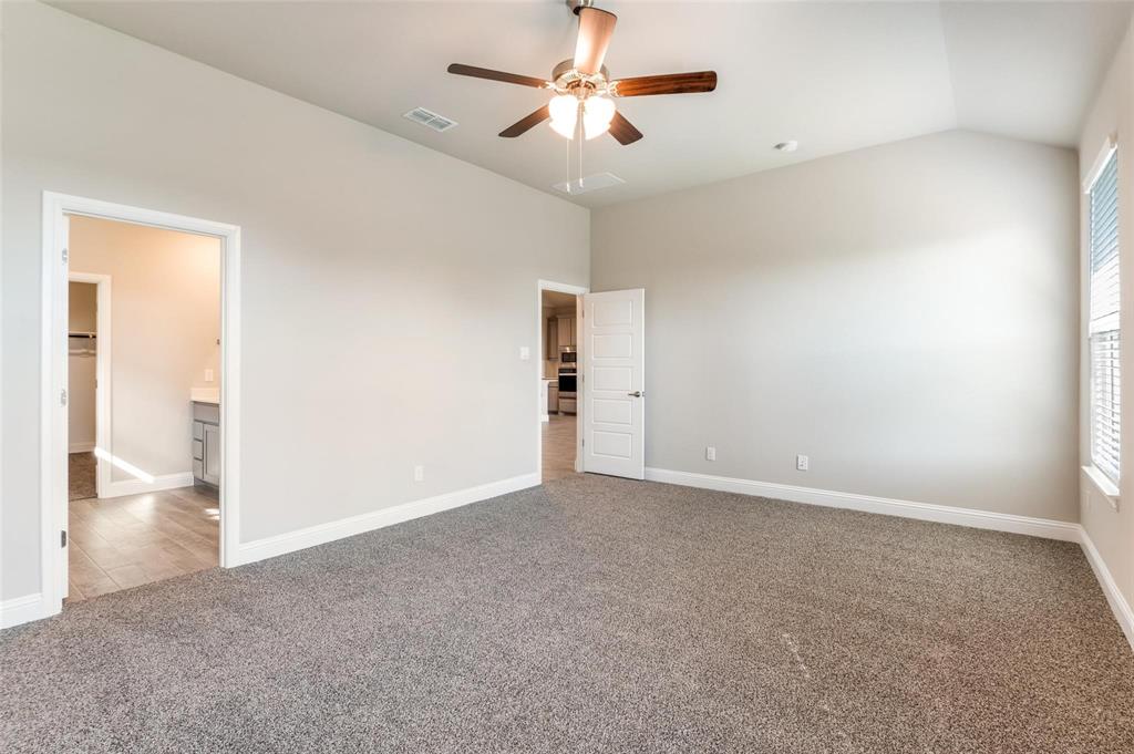 1517 Razorbill Road Denton, TX 76205 - Photo 13 of 25 Spacious interior featuring neutral carpeting, a vaulted ceiling, and a ceiling fan with light fixture