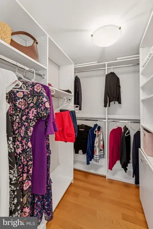 a view of walk in closet with clothes and shoes