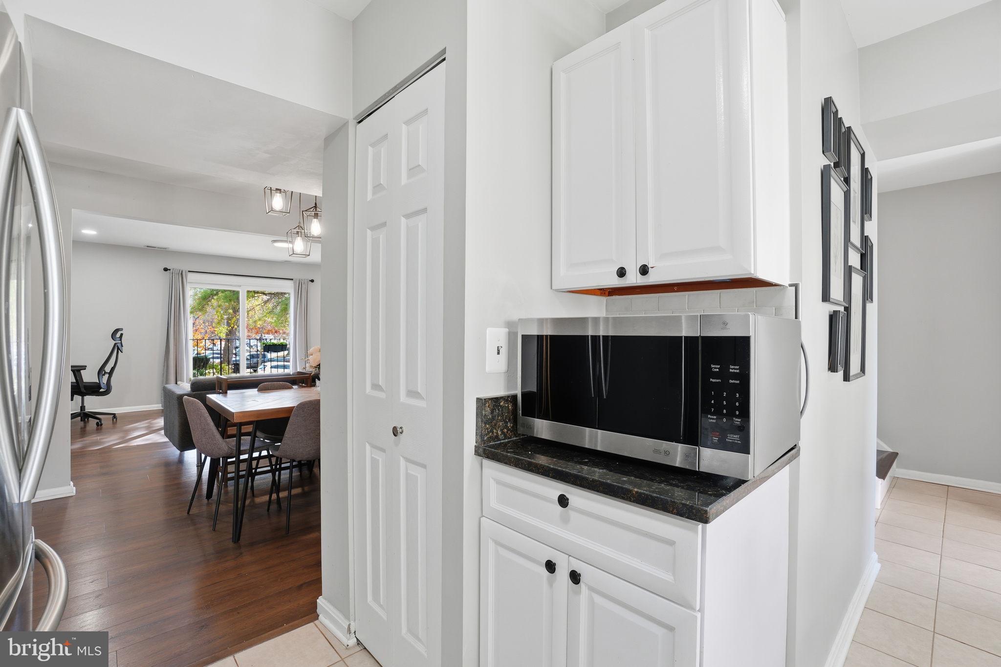 9175 Broken Oak Place, Unit 39B Burke, VA 22015 - Photo 15 of 35 a kitchen with stainless steel appliances a stove a microwave and white cabinets