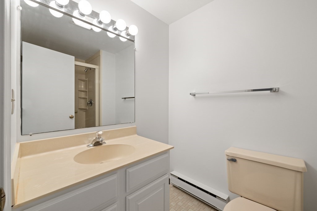 174 Lowell Road, Unit 135 Mashpee, MA 02649 - Photo 11 of 21 a bathroom with a sink a toilet and a mirror