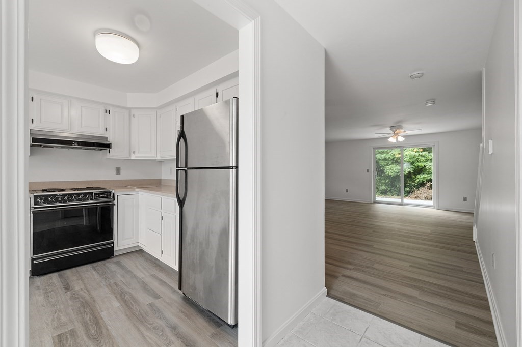 174 Lowell Road, Unit 135 Mashpee, MA 02649 - Photo 3 of 21 a kitchen with a refrigerator stove and wooden cabinets