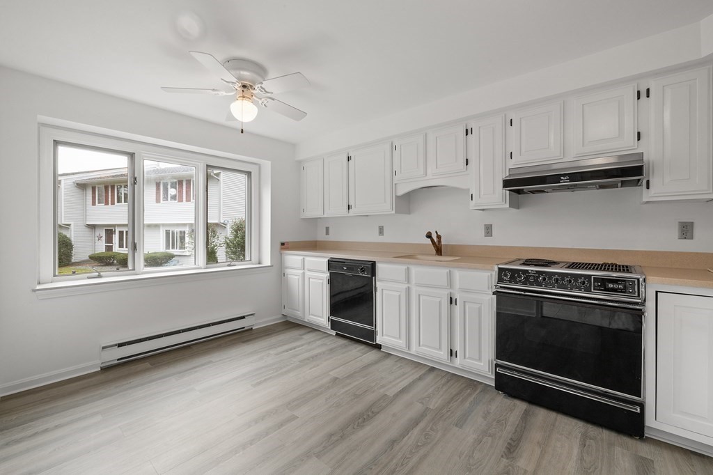 174 Lowell Road, Unit 135 Mashpee, MA 02649 - Photo 4 of 21 a kitchen with stainless steel appliances granite countertop a stove a sink and white cabinets