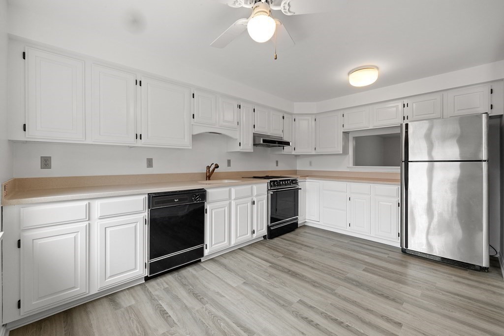 174 Lowell Road, Unit 135 Mashpee, MA 02649 - Photo 5 of 21 a kitchen with a white cabinets and white appliances