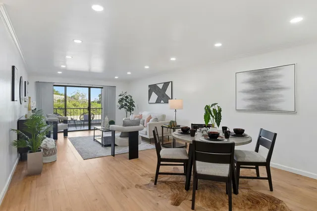 a living room with furniture and potted plants with wooden floor