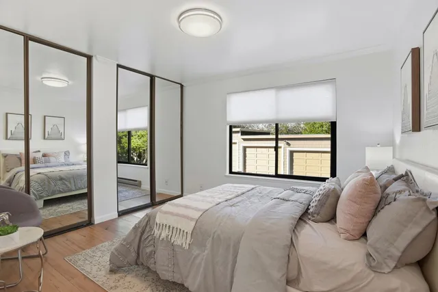 a bedroom with a bed and a large window