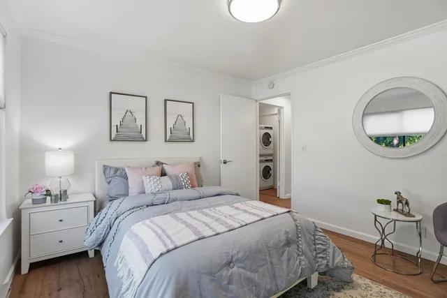 a bedroom with a bed and a chair with the wooden floor