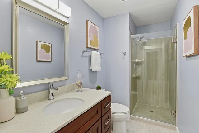 a bathroom with a granite countertop sink toilet and shower